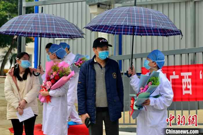 图为广西版“小汤山”医务人员送治愈患者离开。 李安祺 摄 广西版“小汤山”医院在院治疗近半数确诊患者治愈出院